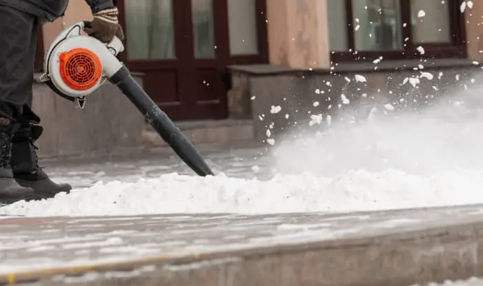Removing snow from pavement with leaf blower
